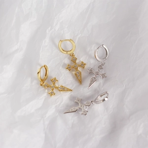 Close-up of gold and silver S925 sterling silver cross earrings with sparkling cubic zirconia