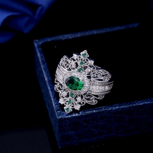Detail of vintage emerald ring with silver hollow filigree on navy jewelry box