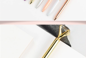Close-up of elegant metal pens with large crystal diamond top in multiple metallic colors