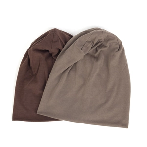 Close-up of dark brown and light coffee knitted beanies showing soft cotton texture