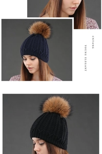 Detail of cable knit beanies with fluffy faux fur pom poms in navy blue and black