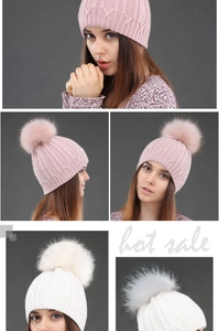 Detail of cable knit pattern and fluffy pompom on winter beanies in pink and white