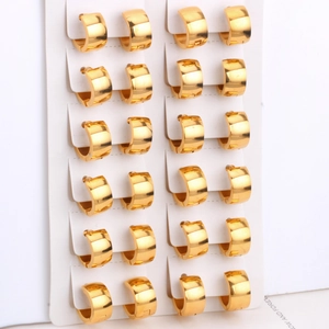 Macro shot of gold hoop earrings displayed on white cards with shiny metallic finish