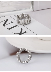 Detail of silver crown ring with star cutout, white diamonds and twisted rope texture