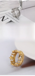 Detail of crown and star rings with inlaid crystals in gold and silver finish