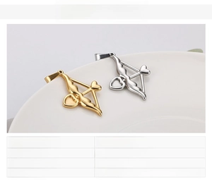 Détail du pendentif flèche de Cupidon en finition or et argent sur une assiette