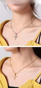 Close-up of gold and silver angel wing pendants on necklaces worn by a model
