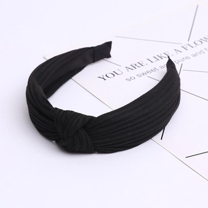 Detailed texture of black ribbed knit fabric on a wide cross-knot headband for women