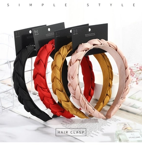 Detail of four colorful braided fabric headbands displayed on professional cards