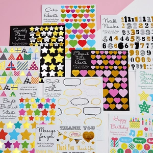 Assorted gold and silver foil decorative stickers with hearts and numbers on pink background