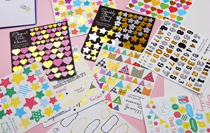 Macro shot of assorted gold and silver foil heart and star stickers for DIY crafts