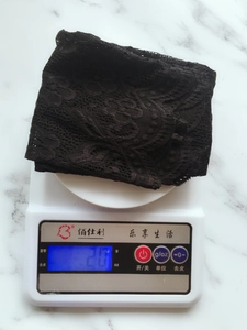 Detail showing lightweight 20g black lace cooling arm sleeve on a digital scale