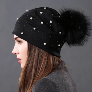 Black knit beanie for women featuring pearl accents and a large fluffy fur pompom
