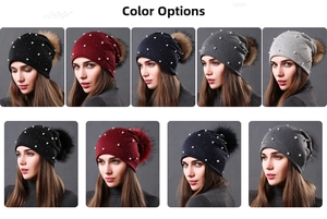 Detail of double-layer knit beanies with pearl accents and faux fur pom-poms in various colors