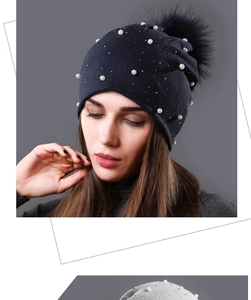 Detailed view of navy blue and light grey beanies with pearl and rhinestone accents