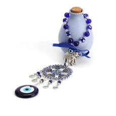Detailed view of evil eye keychain with silver elephant charm and blue ceramic bottle