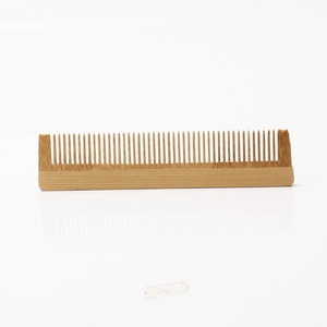 Detail of eco-friendly bamboo hotel comb with fine teeth and natural wood finish