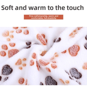Close-up of soft thick flannel pet blanket with orange and grey paw prints detail