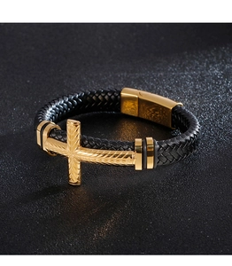 Macro shot of men's woven leather bracelet with gold cross pendant and magnetic buckle
