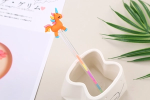 Macro detail of a cute orange unicorn stirrer with rainbow mane in a white ceramic cup