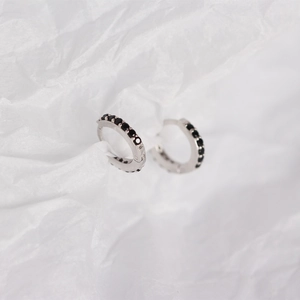 Detailed close-up of 925 sterling silver hoop earrings featuring black diamond pavé setting