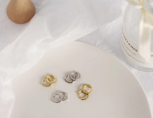 Macro shot of gold and silver S925 sterling silver hoop earrings with cubic zirconia stones