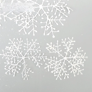 Close-up of white glitter snowflake ornaments in various sizes for Christmas decor