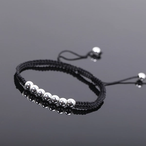 Detailed shot of handmade woven black cord bracelet with polished silver beads and pull closure