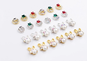 Macro shot of 3D rabbit nail art charms with pearls and colorful glass gemstones