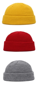 Detailed knit texture of red, yellow, and grey winter beanies in a stack