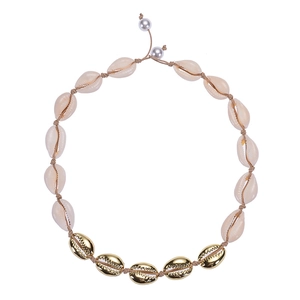 Detail view of a shell necklace with natural shell pendants and golden metal accents