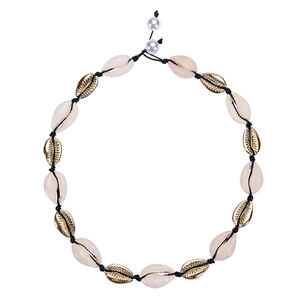 Detail of a handmade necklace with gold shells, white shells and black cord