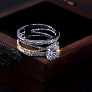 Bague géométrique bicolore avec zircon rond sur une boîte à bijoux en bois vintage