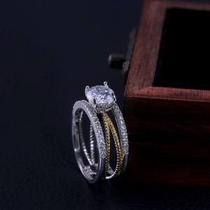 Détail d'une bague bicolore 14K avec zircons étincelants et anneau torsadé multicouche