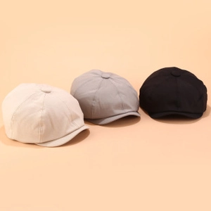 Drei Schirmmützen aus Tweed in Beige, Grau und Schwarz auf einem neutralen Hintergrund