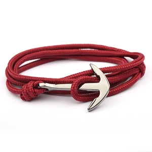 Handmade red nylon rope anchor bracelet with polished silver nautical clasp on white background