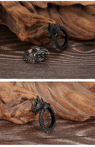 Detailed close-up of dragon head rings with intricate scale textures on vintage wood