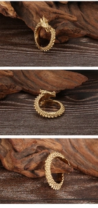 Detailed macro shots of vintage dragon ring featuring gold scales on dark wood background