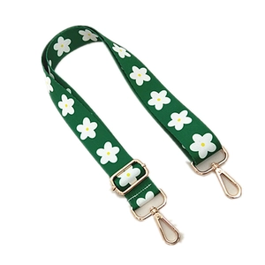 Close-up of adjustable green strap with white flower patterns and gold lobster clasps