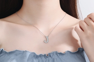 Detailed close-up of a silver letter J pendant necklace with sparkling pavé crystals