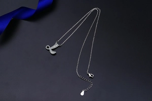 Macro shot of silver S925 letter L pendant necklace with pave diamonds and lobster clasp
