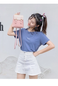 Mini sac à dos en similicuir rose et beige porté avec une tenue décontractée sur banc