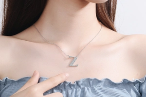 Close-up of a silver Z-letter pendant necklace with sparkling diamonds on a model