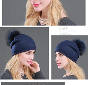 Viste dettagliate di un cappello di lana lavorato a maglia blu navy con pompon di pelliccia