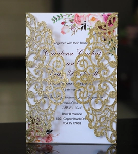 Detail of laser-cut gold glitter wedding invitation with elegant pink floral inner card
