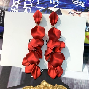 Detailed close-up of matte red rose petal earrings with elegant gold link rings