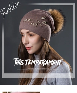 Détail du bonnet en maille mauve orné de perles avec un pompon en fausse fourrure soyeuse