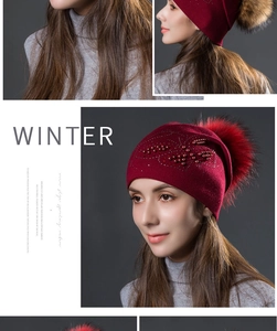 Détail du bonnet en tricot bordeaux avec strass, perles et un grand pompon en fourrure