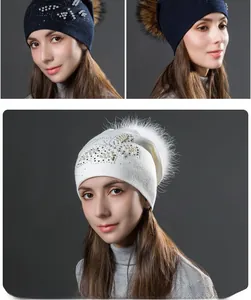 Détail du bonnet en maille avec pompon en fausse fourrure et papillon en perles strass