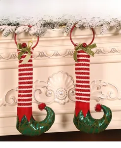 Detail of Christmas elf leg wreath with sequined boots and bells on a fireplace mantle